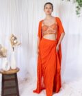 Orange draped saree with mirror work choli and cape