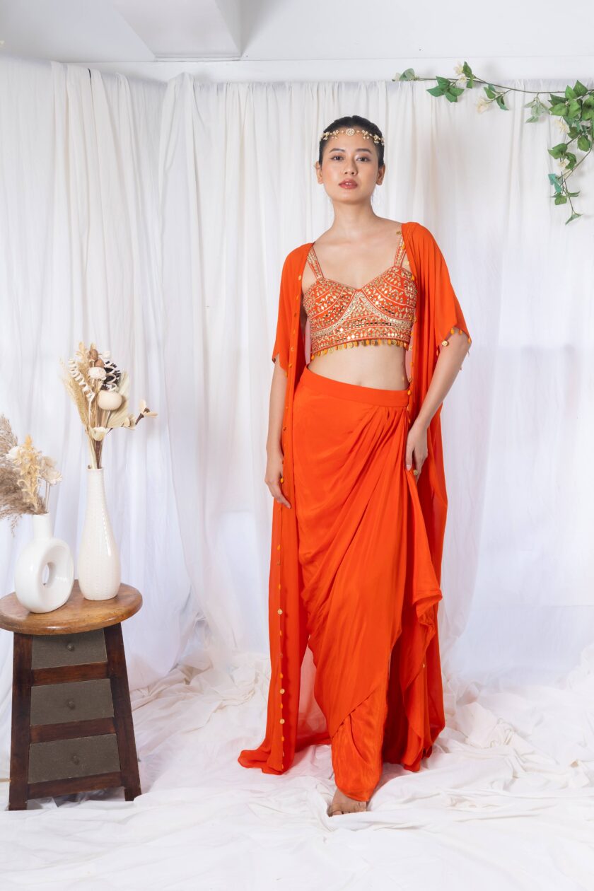 Orange draped saree with mirror work choli and cape